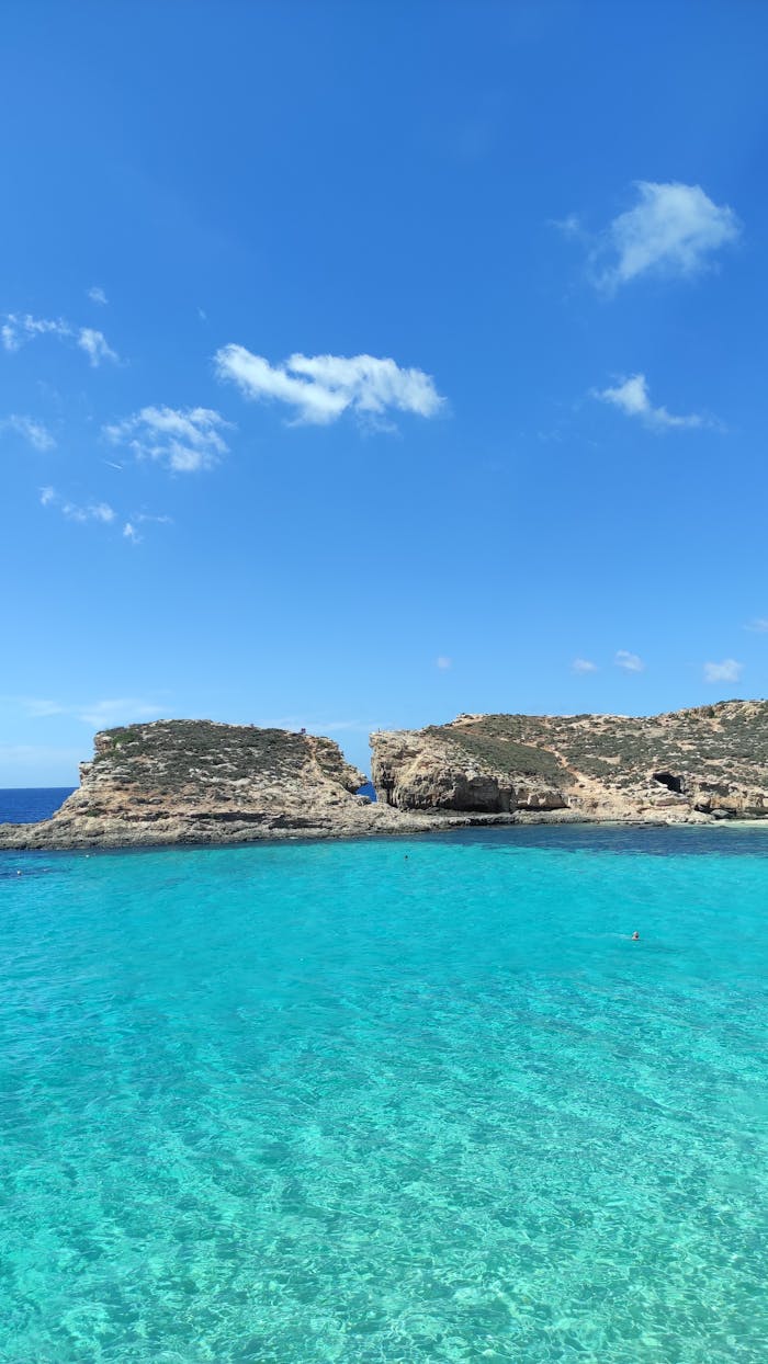 Stunning view of clear turquoise sea and rocky cliffs at Malta's Blue Lagoon, perfect for travel inspiration.